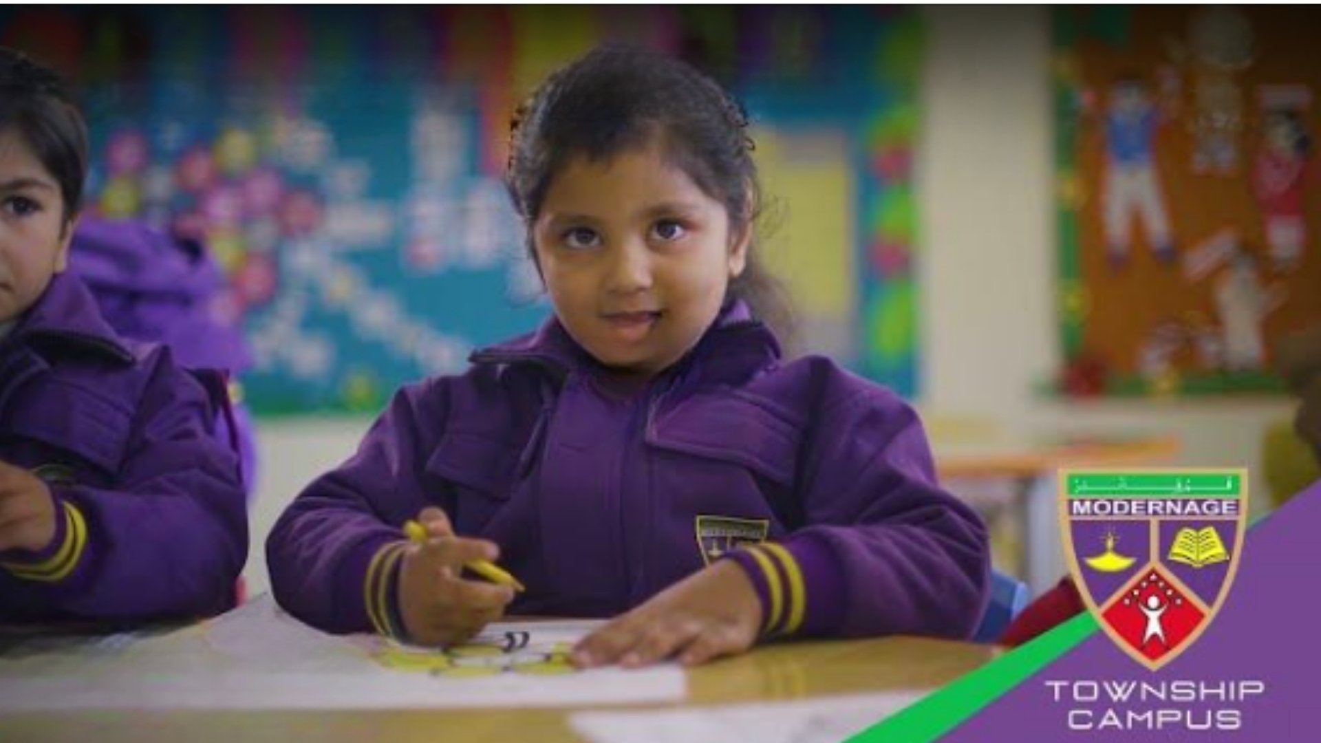 A kindergarten student at Modernage Township Campus enjoys coloring,