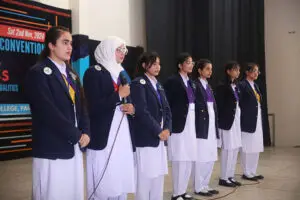 Students in blue blazers presenting on stage