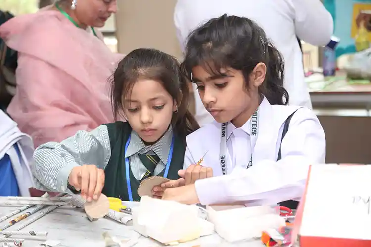 Two girls making crafts in school workshop