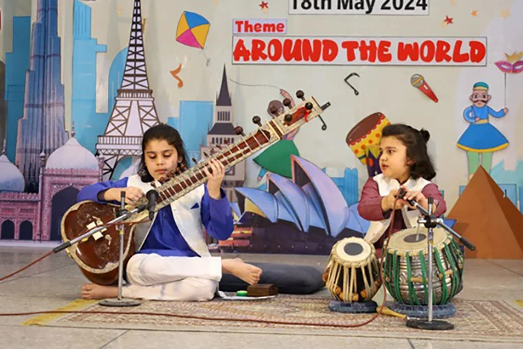 Girls playing sitar and tabla at school function