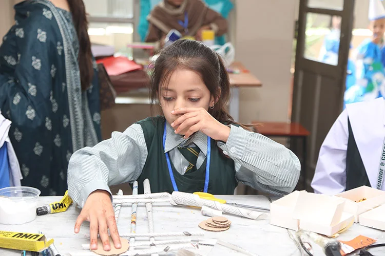 Girl assembling craft project with paper rolls