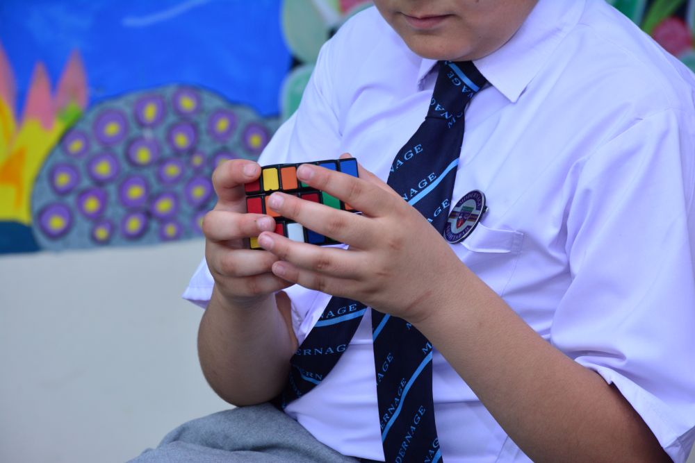 Modernage student solving colorful Rubik's cube