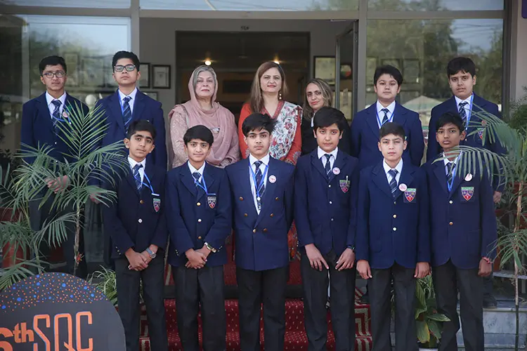 Students in blue blazers presenting on stage
