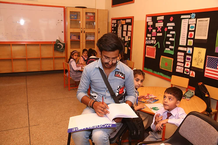 Teacher helping students in classroom activity